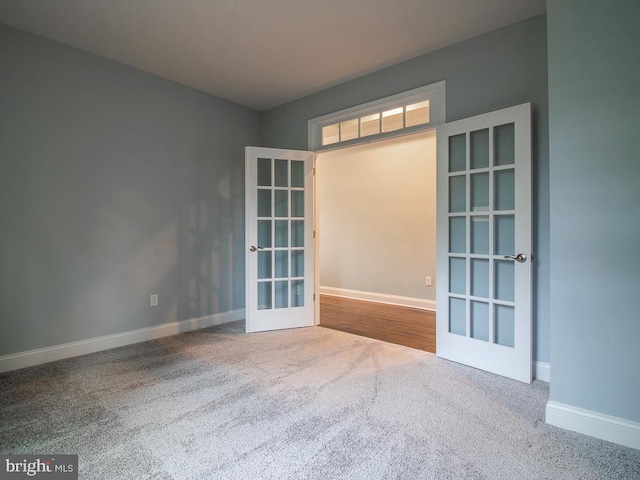 carpeted empty room featuring french doors