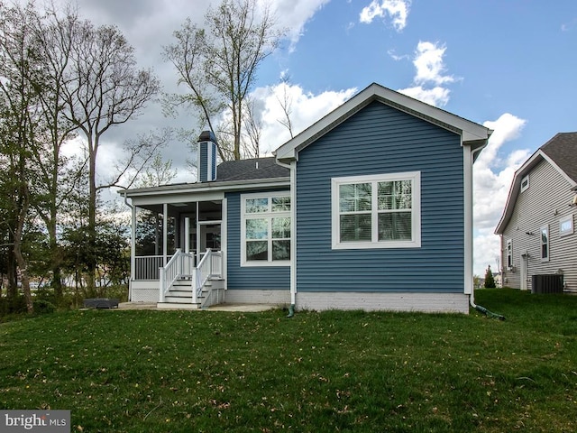 back of property with a yard and central air condition unit