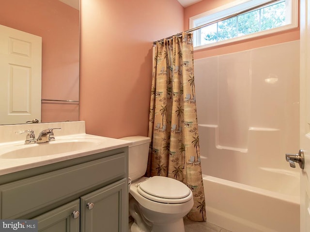 full bathroom with tile floors, vanity with extensive cabinet space, toilet, and shower / bath combo with shower curtain