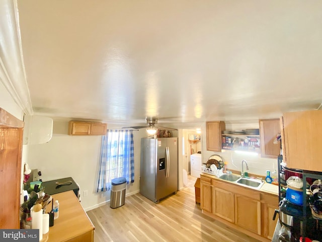 kitchen featuring stainless steel fridge, ceiling fan, sink, light hardwood / wood-style floors, and washer / clothes dryer