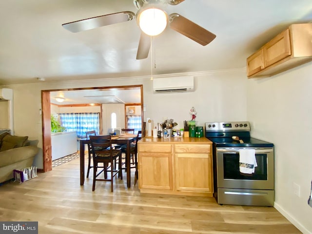 kitchen featuring a wall unit AC, ceiling fan, light wood-type flooring, and stainless steel range with electric stovetop