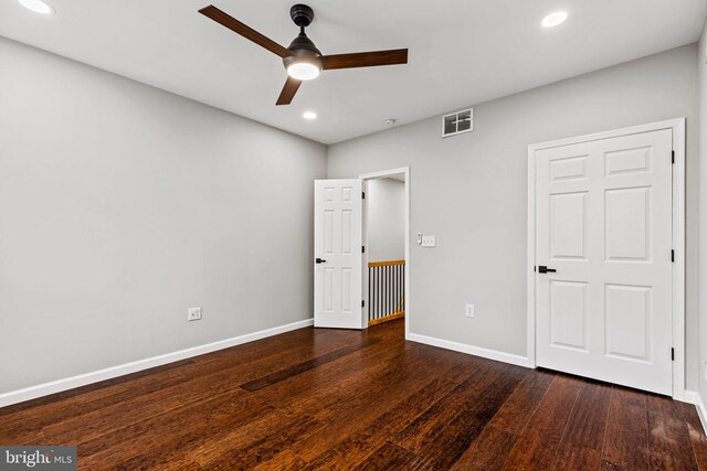 unfurnished bedroom with ceiling fan and dark hardwood / wood-style flooring