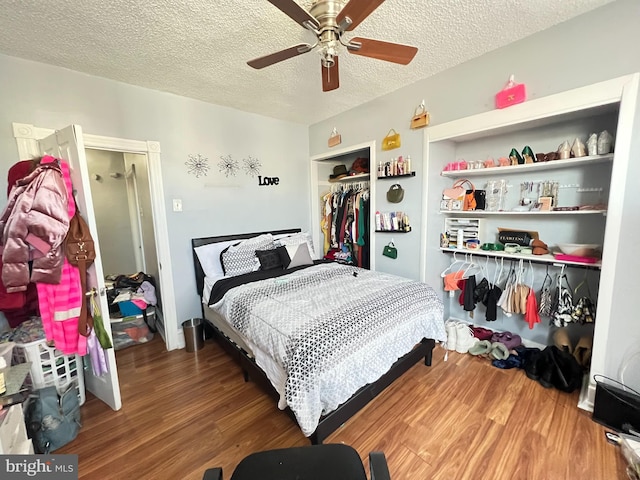 bedroom with a closet, a textured ceiling, wood-type flooring, and ceiling fan