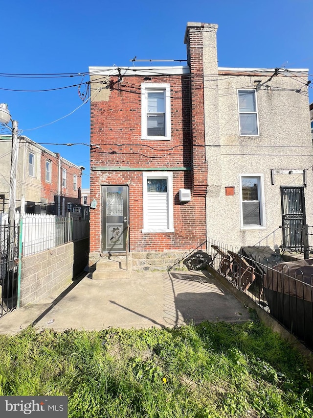 rear view of house featuring a patio and a wall unit AC