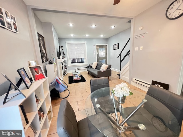 tiled dining space featuring ceiling fan and a baseboard radiator