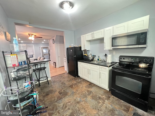 kitchen featuring dark tile floors, ceiling fan, black appliances, and white cabinetry