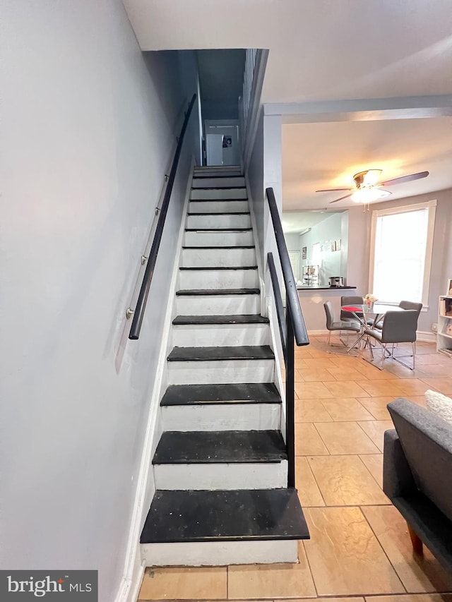 stairway with light tile floors and ceiling fan