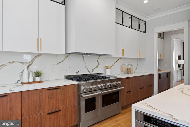 kitchen featuring white cabinets, double oven range, light stone countertops, tasteful backsplash, and light wood-type flooring