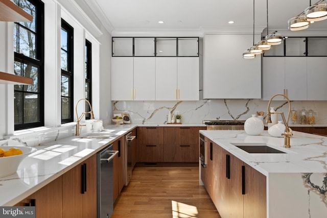 kitchen with white cabinets, decorative light fixtures, light hardwood / wood-style flooring, and light stone counters