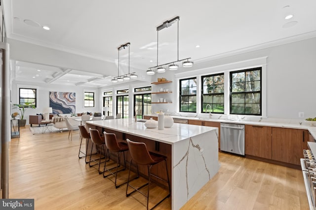 kitchen featuring light stone countertops, decorative light fixtures, dishwasher, and light wood-type flooring