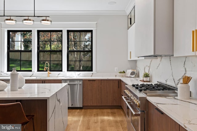 kitchen with white cabinets, light hardwood / wood-style flooring, light stone counters, and stainless steel appliances