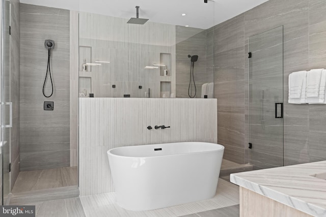 bathroom featuring vanity, tile walls, plus walk in shower, and tile floors