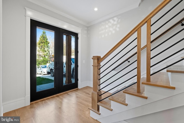 entryway with french doors, light hardwood / wood-style floors, and ornamental molding