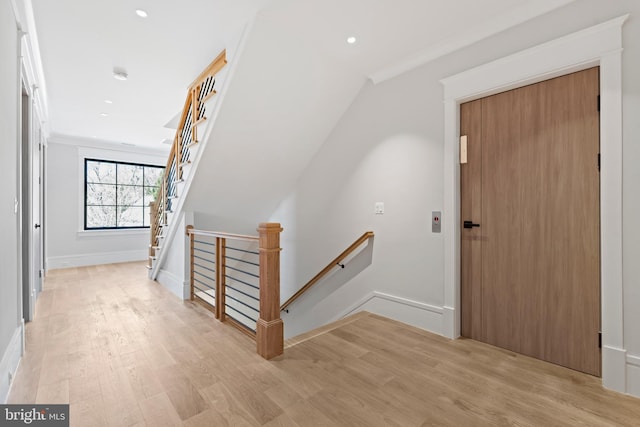 hallway featuring crown molding and light wood-type flooring