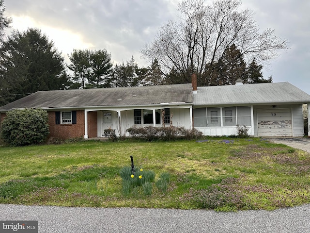 single story home featuring a front lawn and a garage