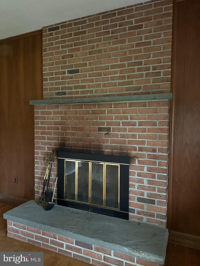 details with wooden walls and a brick fireplace