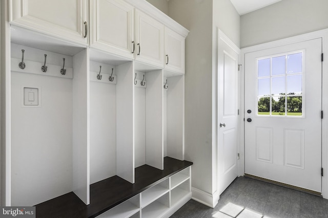 mudroom with dark tile floors