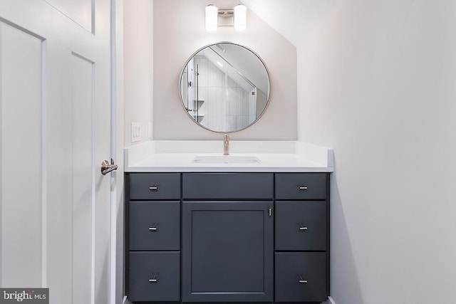 bathroom with vanity and lofted ceiling