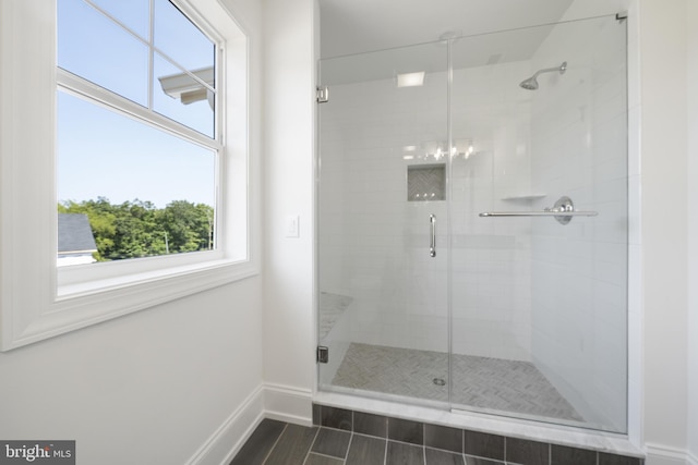 bathroom with a shower with door and tile flooring