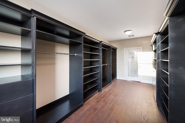 spacious closet with dark hardwood / wood-style flooring