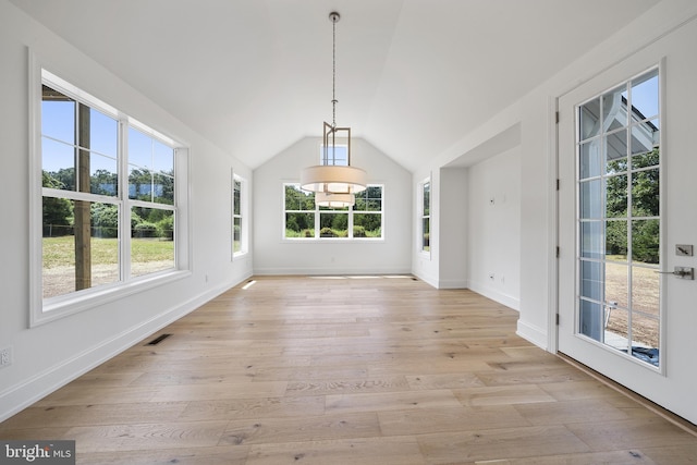 spare room with light hardwood / wood-style floors and vaulted ceiling