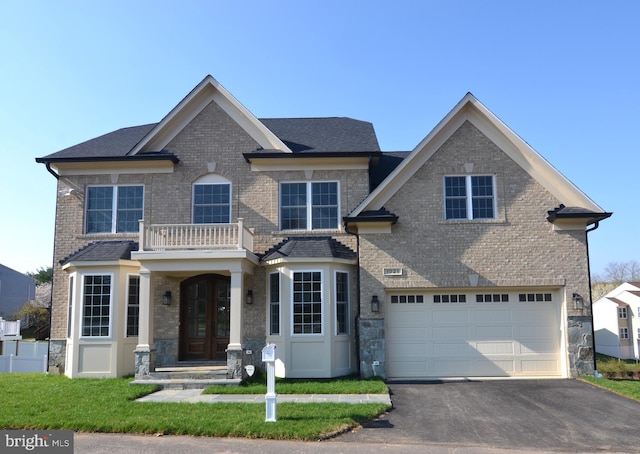 view of front facade with a front lawn, a balcony, and a garage