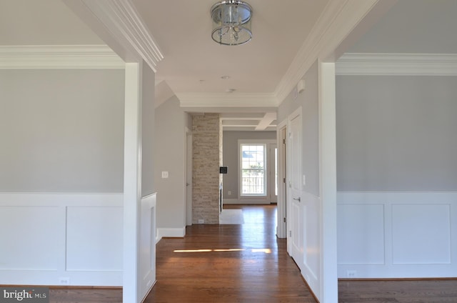 corridor featuring crown molding, decorative columns, brick wall, and dark hardwood / wood-style floors