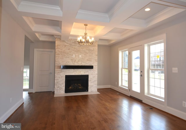 unfurnished living room featuring coffered ceiling, a healthy amount of sunlight, and dark hardwood / wood-style flooring