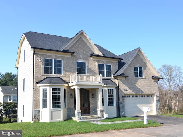 view of front of home with a front lawn, a balcony, and a garage