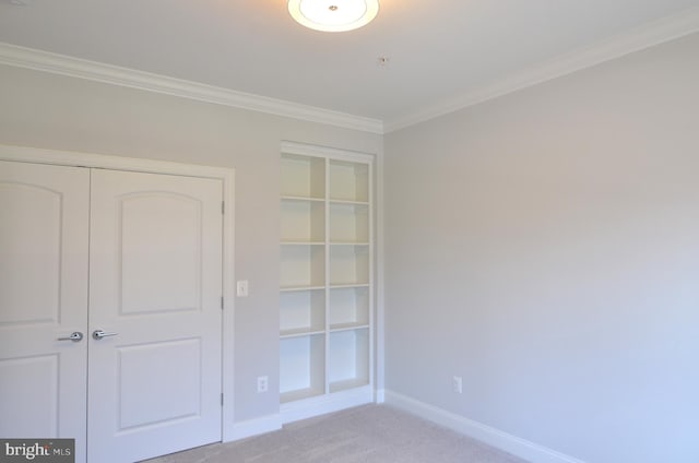 unfurnished bedroom featuring light carpet, ornamental molding, and a closet