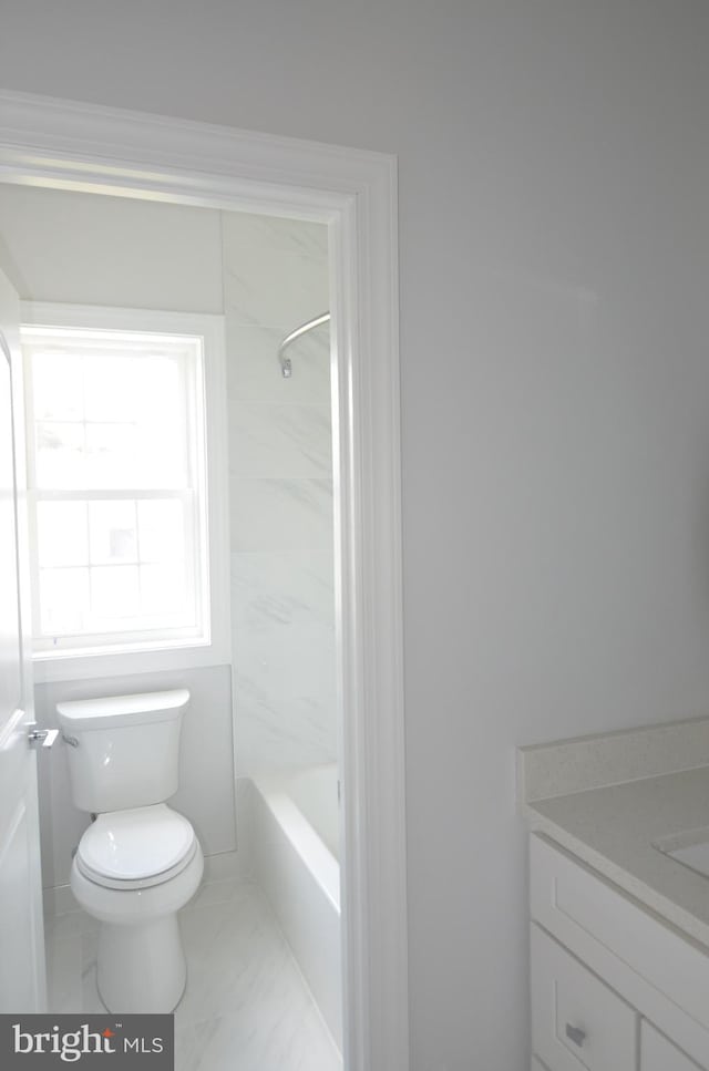 full bathroom featuring tiled shower / bath, toilet, tile floors, and vanity