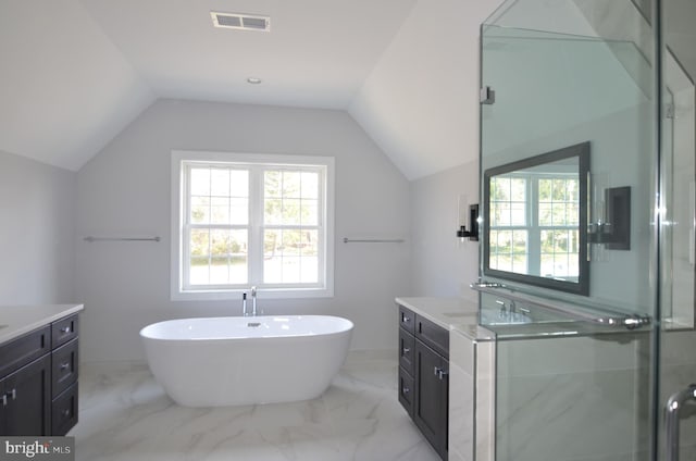 bathroom with tile floors, vanity, and vaulted ceiling