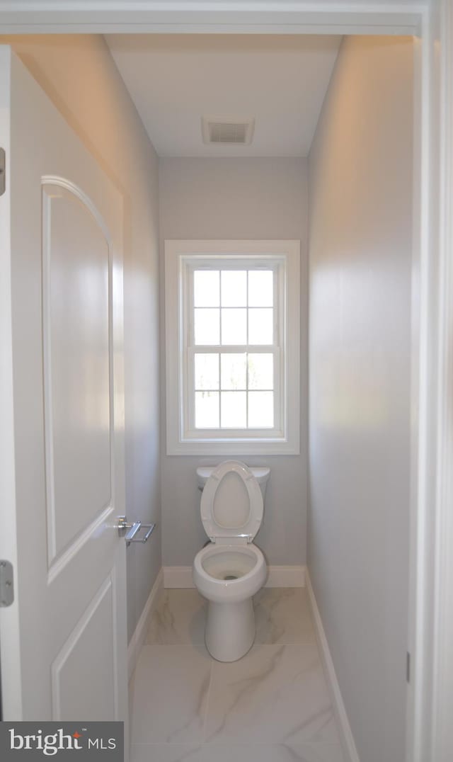 bathroom with toilet and tile floors