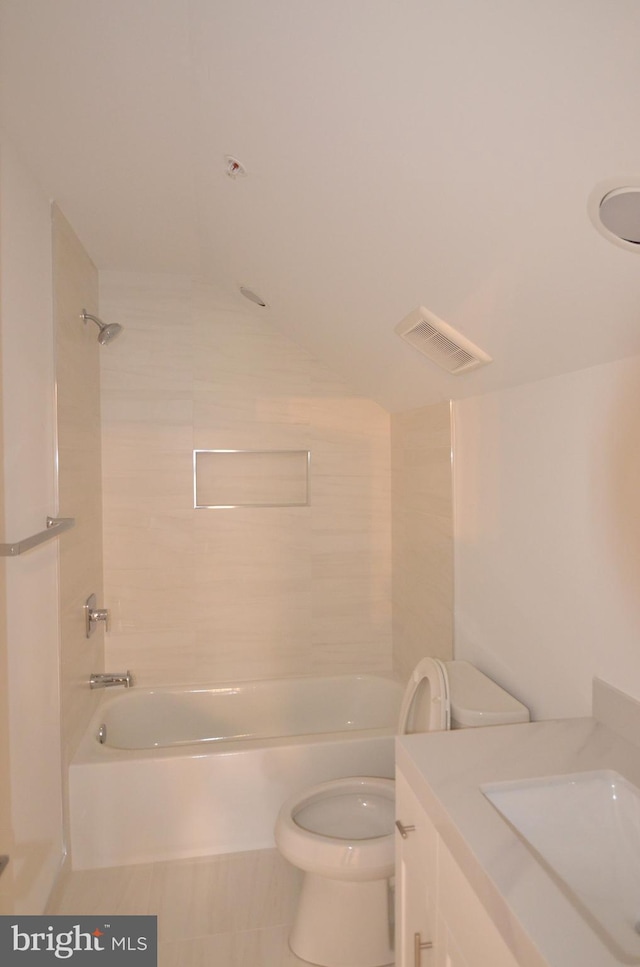 full bathroom featuring toilet, tile flooring, tiled shower / bath combo, and vanity