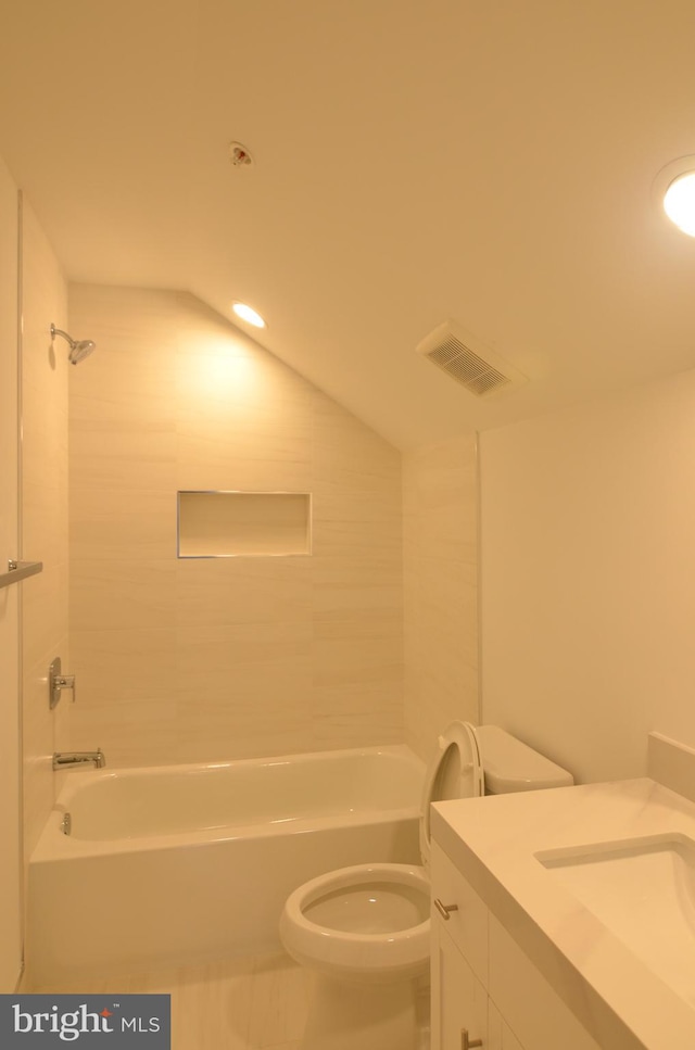 full bathroom with toilet, tiled shower / bath, vaulted ceiling, tile flooring, and vanity