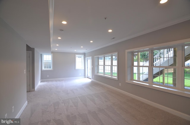 unfurnished room featuring ornamental molding and light colored carpet