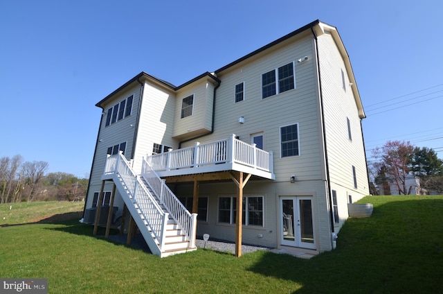 rear view of house with a wooden deck, french doors, and a yard