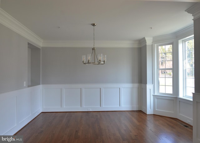 unfurnished room with ornamental molding, dark hardwood / wood-style floors, and a chandelier