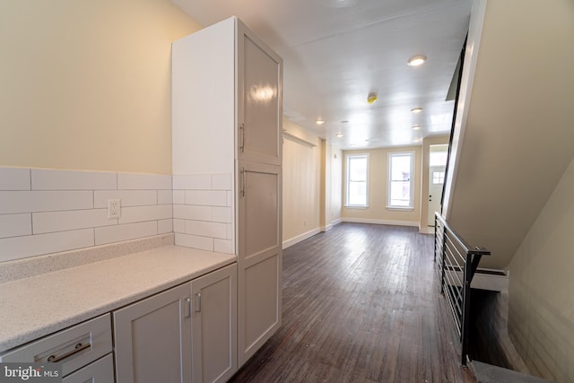 interior space featuring white cabinetry, dark hardwood / wood-style floors, and backsplash