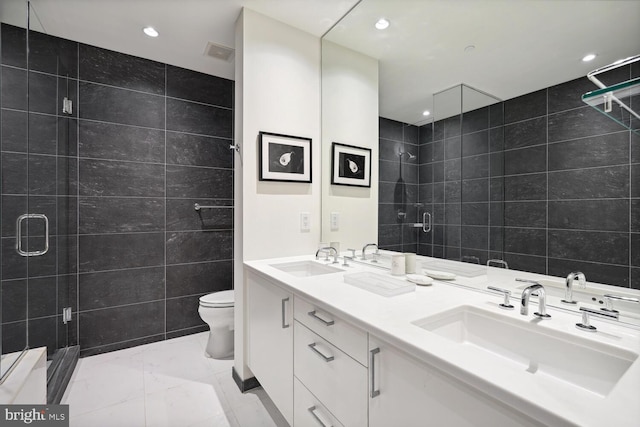 bathroom featuring an enclosed shower, tile flooring, double vanity, and tile walls