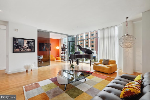 living room with a wall of windows and light wood-type flooring