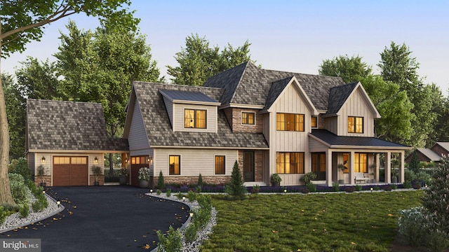 view of front of house with aphalt driveway, an attached garage, an outdoor structure, a front lawn, and board and batten siding