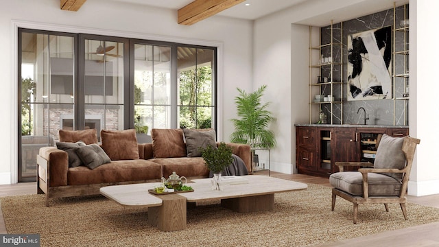 living area with baseboards, wood finished floors, and beamed ceiling