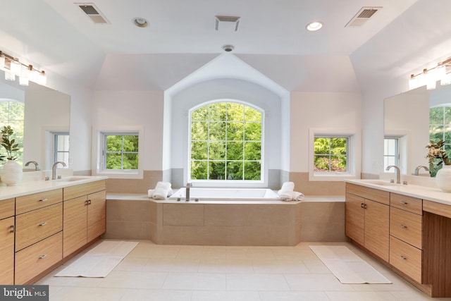 bathroom featuring dual bowl vanity, tile floors, a relaxing tiled bath, and lofted ceiling