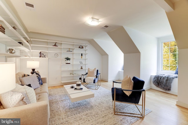 living room featuring lofted ceiling and light wood-type flooring