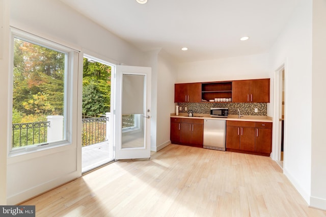 kitchen with tasteful backsplash, light hardwood / wood-style flooring, dishwasher, and sink