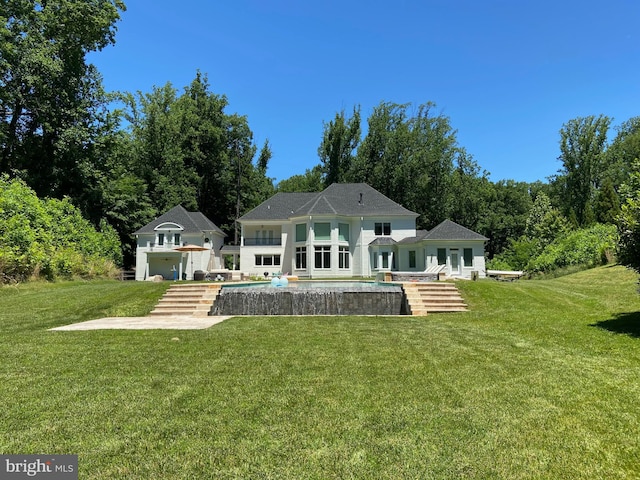 rear view of house with a yard and a patio area