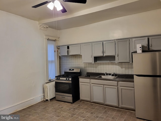 kitchen with radiator heating unit, gray cabinets, ceiling fan, and appliances with stainless steel finishes