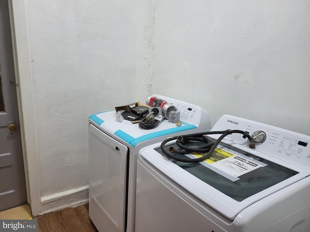 washroom featuring dark hardwood / wood-style flooring and washing machine and clothes dryer