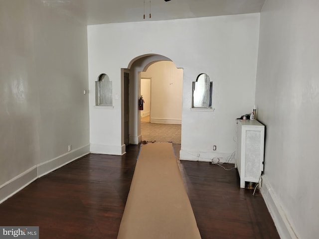 empty room with ceiling fan and dark wood-type flooring